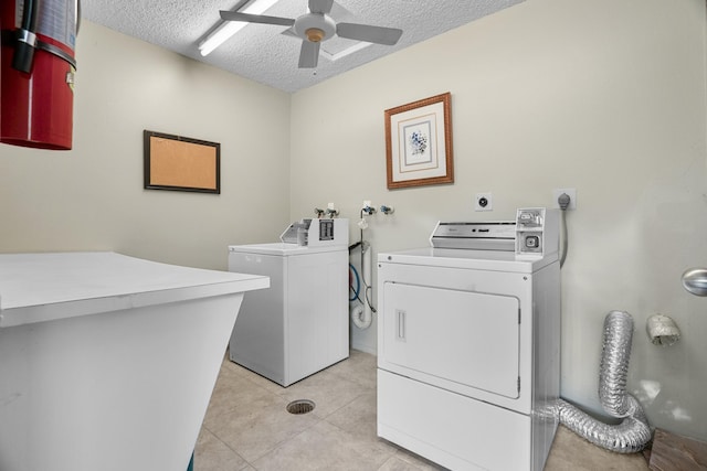 washroom featuring a textured ceiling, ceiling fan, light tile patterned floors, and washer and clothes dryer