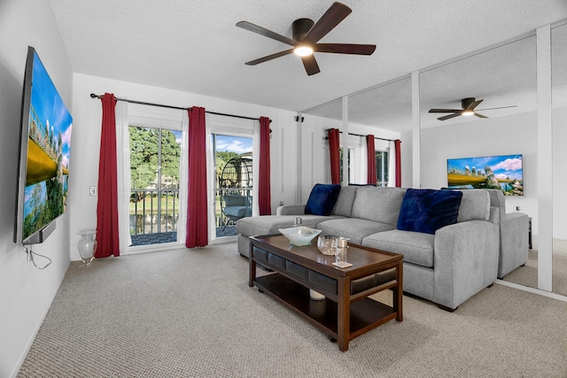 living room featuring a textured ceiling, light colored carpet, and ceiling fan