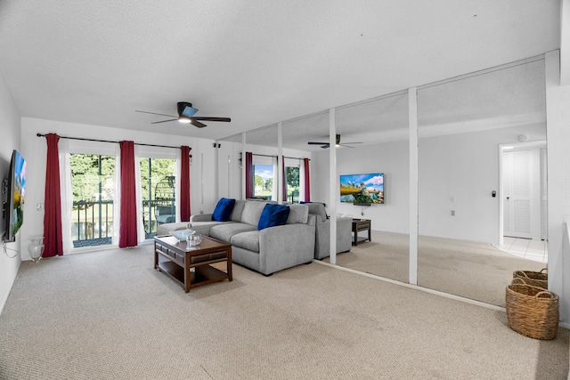 living room featuring ceiling fan, light carpet, and a textured ceiling