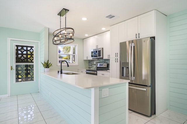 kitchen featuring pendant lighting, stainless steel appliances, white cabinetry, and sink