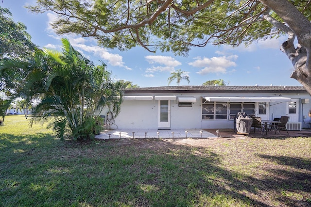 rear view of property with a yard and a patio