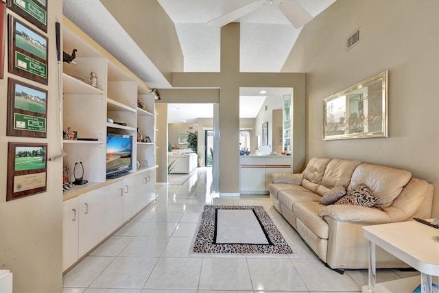 tiled living room featuring ceiling fan, high vaulted ceiling, and a textured ceiling