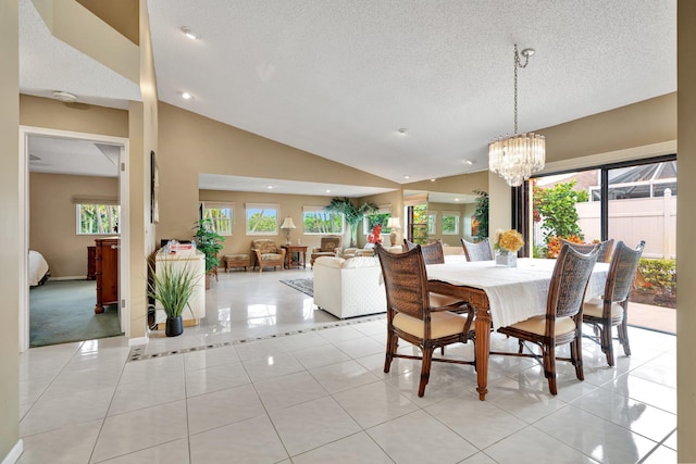 dining area with a chandelier, plenty of natural light, lofted ceiling, and light tile patterned flooring