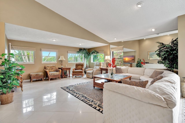 living room featuring lofted ceiling, a textured ceiling, a wealth of natural light, and light tile patterned flooring