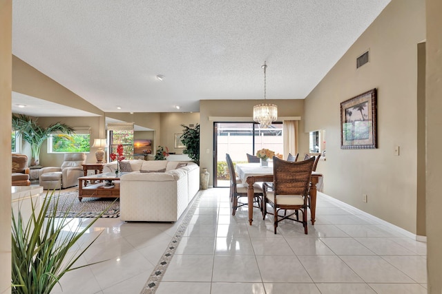 tiled dining space featuring a textured ceiling, lofted ceiling, and a notable chandelier