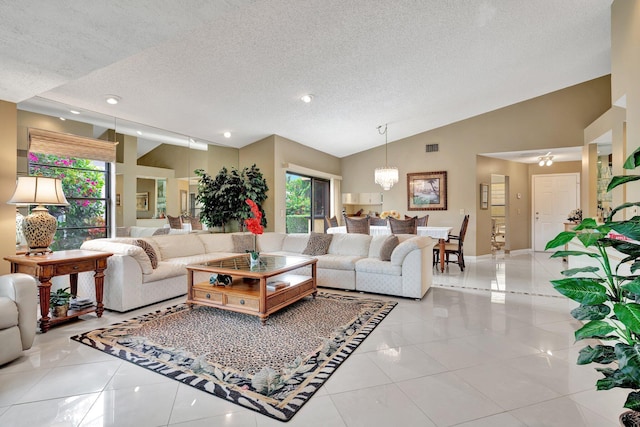 tiled living room with a textured ceiling, high vaulted ceiling, and an inviting chandelier