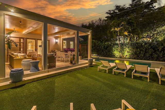 yard at dusk featuring outdoor lounge area and a patio