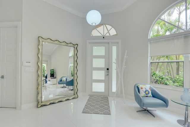 tiled foyer with a wealth of natural light and ornamental molding