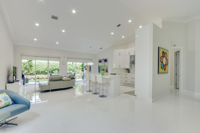 living room with light tile patterned floors and ornamental molding