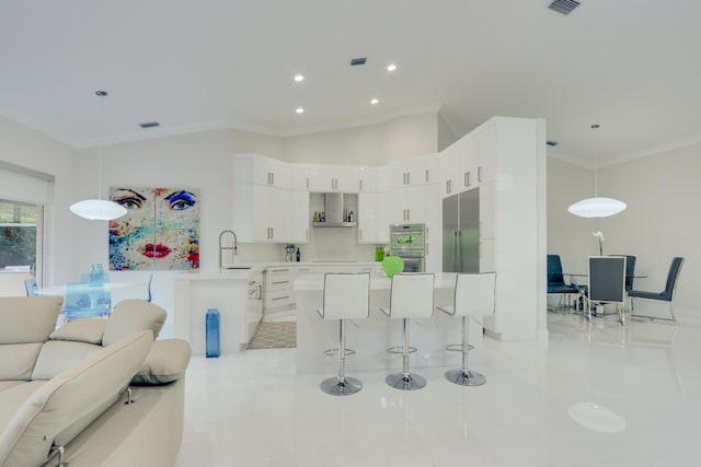 kitchen with ornamental molding, sink, light tile patterned floors, white cabinetry, and hanging light fixtures