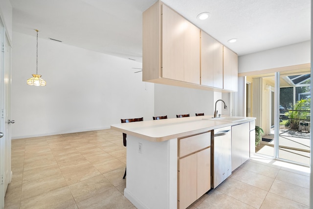 kitchen featuring kitchen peninsula, dishwasher, sink, and hanging light fixtures