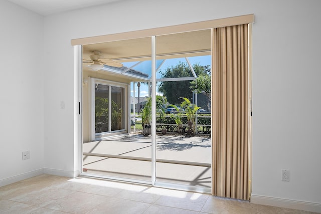 doorway with ceiling fan and light tile patterned flooring