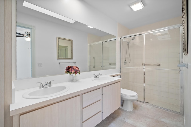 bathroom featuring vanity, toilet, an enclosed shower, and ceiling fan