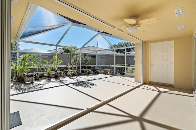 unfurnished sunroom featuring ceiling fan