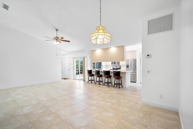 dining area featuring ceiling fan, light tile patterned floors, and high vaulted ceiling