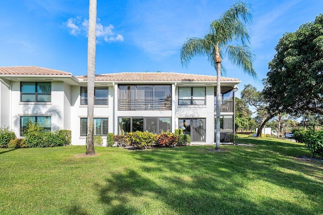 rear view of house featuring a lawn