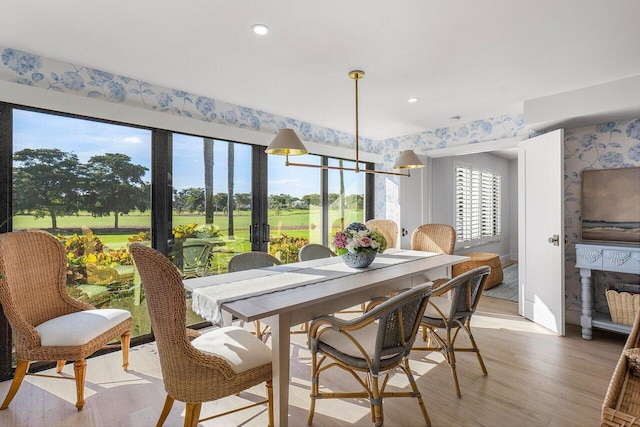 dining space with a notable chandelier and light hardwood / wood-style floors