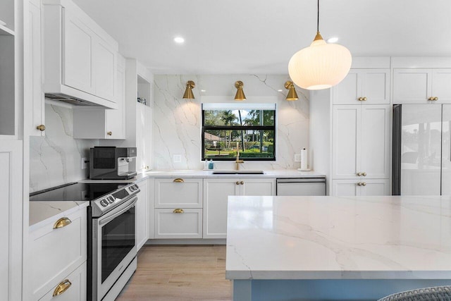 kitchen featuring stainless steel appliances, white cabinets, decorative light fixtures, backsplash, and sink