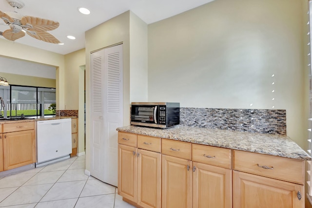 kitchen with white dishwasher, ceiling fan, light stone countertops, and light brown cabinetry