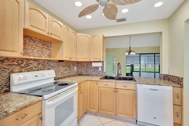 kitchen with sink, hanging light fixtures, white appliances, and light brown cabinets