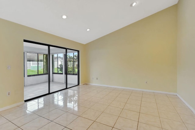 empty room featuring light tile patterned flooring and vaulted ceiling