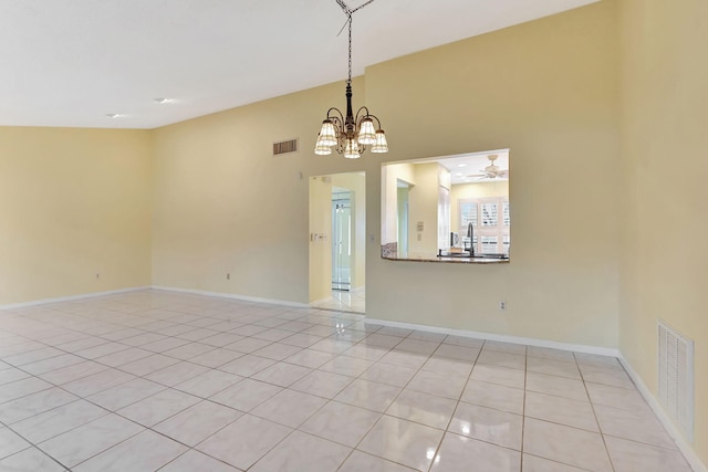 tiled spare room featuring ceiling fan with notable chandelier, high vaulted ceiling, and sink