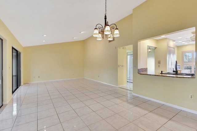 tiled empty room with ceiling fan with notable chandelier and lofted ceiling