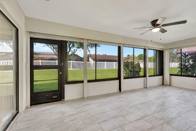 unfurnished sunroom with ceiling fan