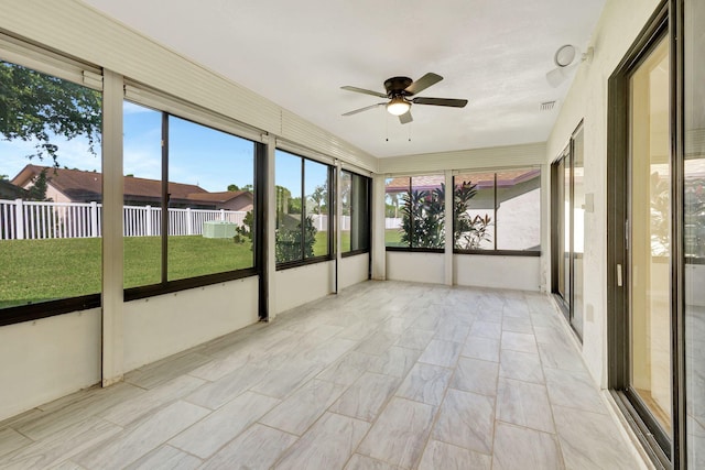 unfurnished sunroom featuring ceiling fan