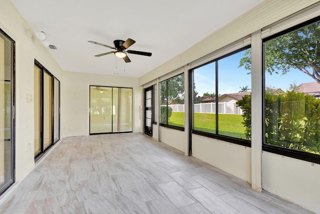 unfurnished sunroom with ceiling fan