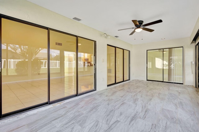 interior space featuring ceiling fan and plenty of natural light