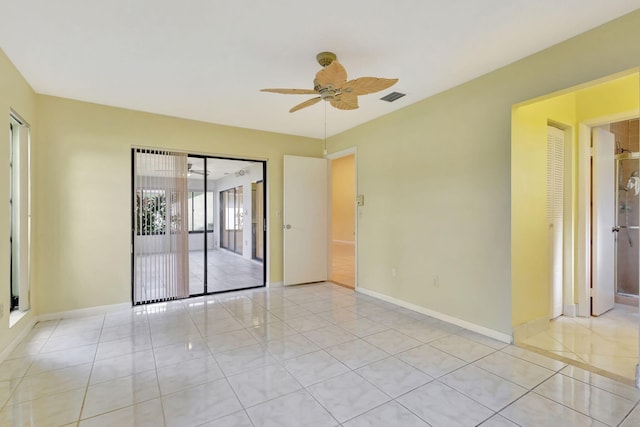 empty room with ceiling fan and light tile patterned floors