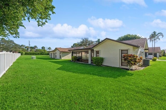 view of yard with a sunroom and central AC unit