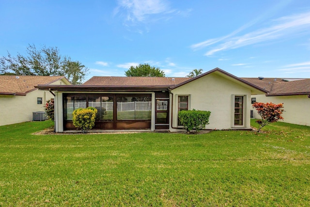 back of property featuring a sunroom, cooling unit, and a lawn