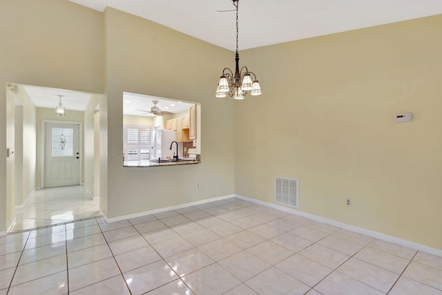 tiled empty room featuring ceiling fan with notable chandelier