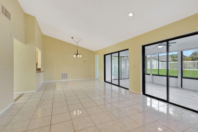 tiled empty room with ceiling fan with notable chandelier and lofted ceiling