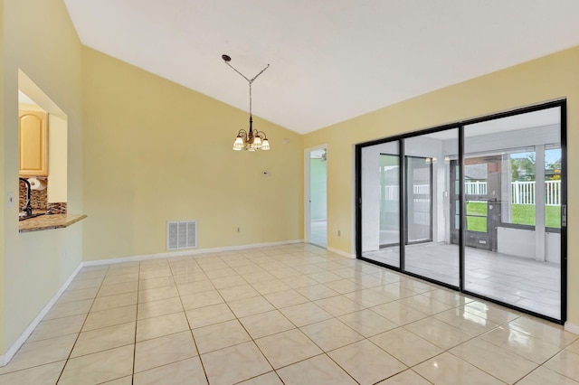 tiled spare room with a notable chandelier and lofted ceiling