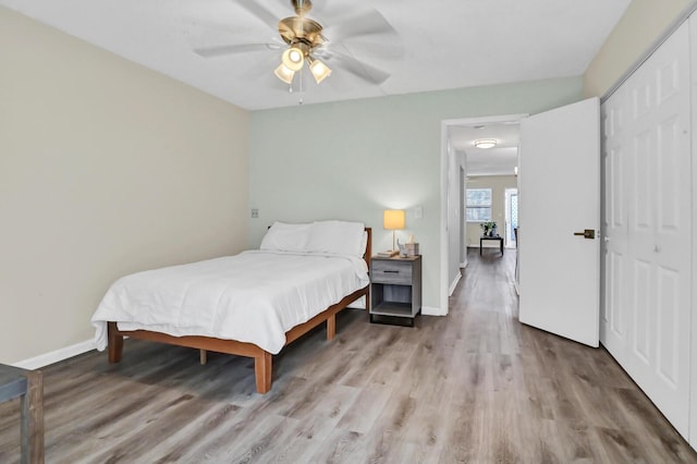 bedroom featuring ceiling fan, a closet, and light hardwood / wood-style floors