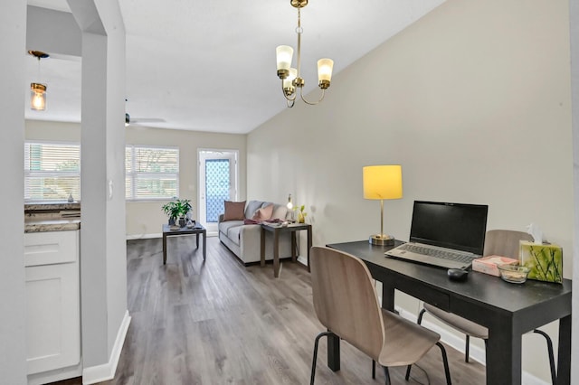 office space with wood-type flooring, ceiling fan with notable chandelier, and lofted ceiling