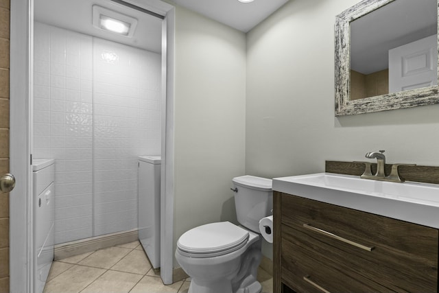 bathroom featuring washer / dryer, tile patterned flooring, vanity, and toilet