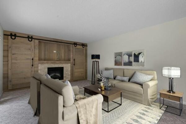 living room featuring light carpet, a barn door, and a fireplace