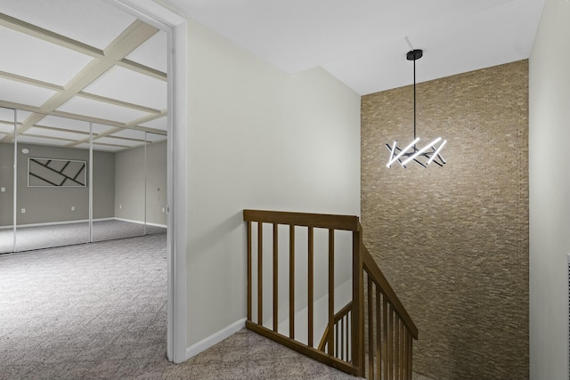 hall with carpet, baseboards, coffered ceiling, and a notable chandelier