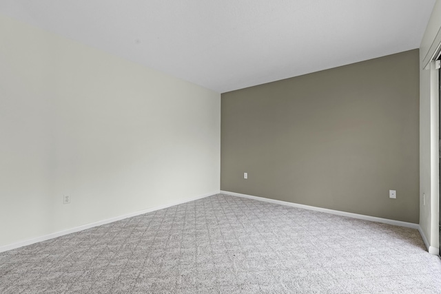 carpeted spare room featuring baseboards