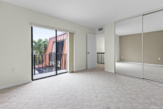 unfurnished bedroom with carpet floors, visible vents, baseboards, access to exterior, and a closet