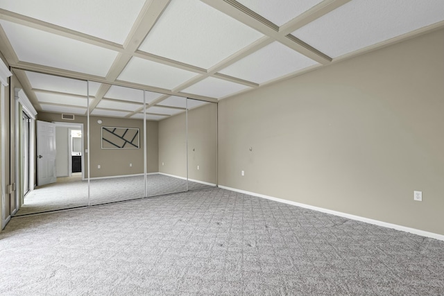 carpeted empty room featuring visible vents, baseboards, coffered ceiling, and beamed ceiling