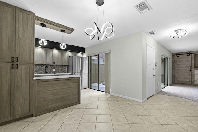 kitchen with visible vents, light countertops, a peninsula, and freestanding refrigerator