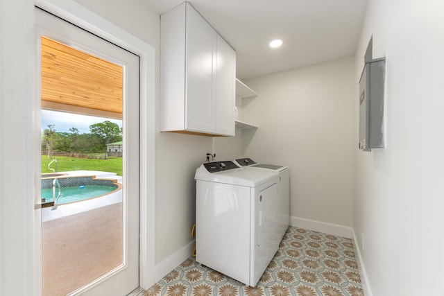 laundry room with cabinets, light tile patterned floors, and separate washer and dryer