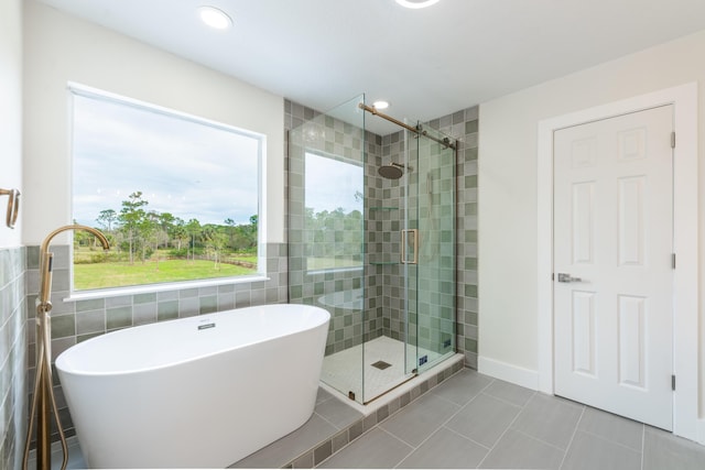 bathroom featuring tile patterned floors, tile walls, and shower with separate bathtub