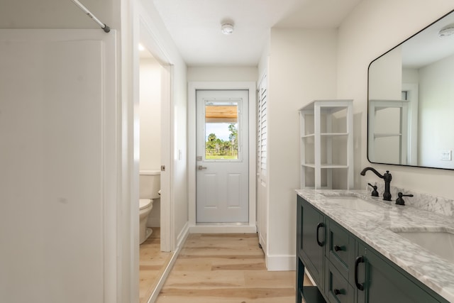 bathroom with hardwood / wood-style flooring, vanity, and toilet