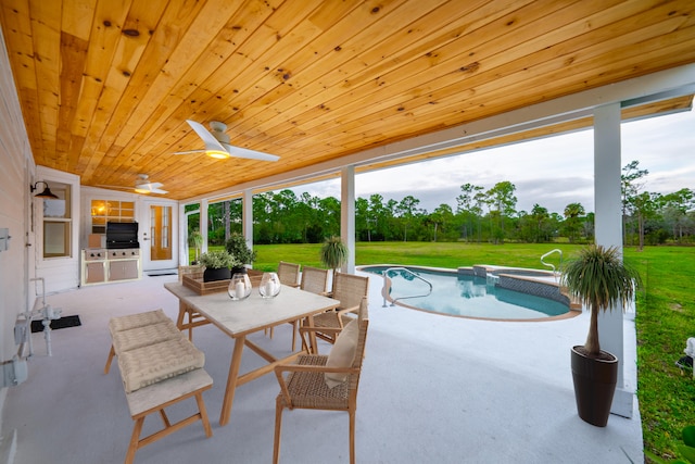 view of swimming pool with a yard, an outdoor kitchen, a patio, and ceiling fan